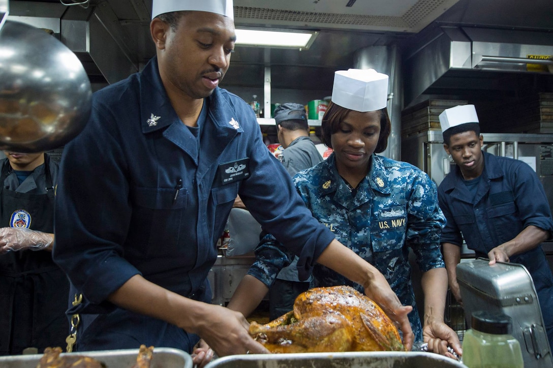 Culinary Specialist 1st Class John Mobley, from Philadelphia, prepares a turkey for carving for a Thanksgiving meal aboard the guided-missile destroyer USS Cole (DDG 67). Cole is conducting naval operations in the U.S. 6th Fleet area of responsibility in support of U.S. national security interests in Europe.