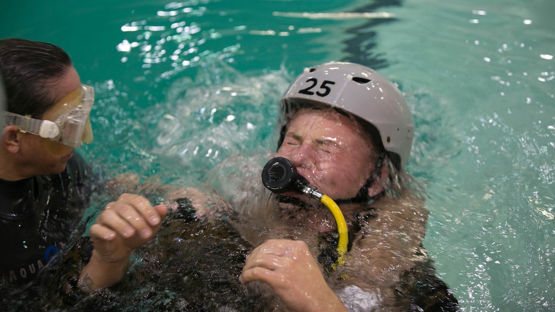 An underwater trainer instructor with the Water Survival Training Facility teaches Lance Cpl. Zachary Felts, an assistant LAAD gunner with 2nd Low Altitude Air Defense Battalion, breathing techniques needed when transitioning from the downward to upright position during a modular amphibious egress training at Marine Corps Base Camp Lejeune, N.C., Nov. 18, 2015. The Marines participated in the training, which is designed to be a lifesaving course that provides service members with skills and the confidence to successfully and safely exit a helicopter that is submerged in a body of water. 