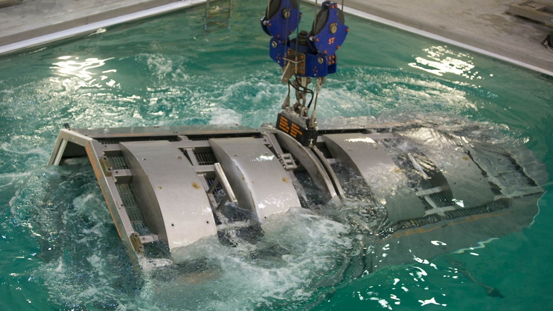 Marines with 2nd Low Altitude Air Defense Battalion and instructors with the Water Survival Training Facility are fully submerged in a pool while aboard a modular amphibious egress mock helicopter during training at Marine Corps Base Camp Lejeune, N.C., Nov. 18, 2015. The Marines participated in the training, which is designed to be a lifesaving course that provides service members with skills and the confidence to successfully and safely exit a helicopter that is submerged in a body of water. 