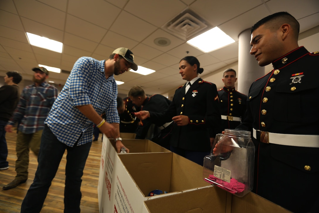 Marines collect toys from concert patrons for Toys for Tots during the 7th annual WRNS Guitar Pull at Marine Corps Air Station Cherry Point, N.C., Nov. 19, 2015. Approximately 2,000 Marines, Sailors and community members gathered for the free concert which was hosted by Marine Corps Community Services and local country music radio station WRNS. The guitar pull featured talents including William Michael Morgan, Cam, Canaan Smith, Cassadee Pope and Waterloo Revival. (U.S. Marine Corps Photo By Cpl. N.W. Huertas/Released)
