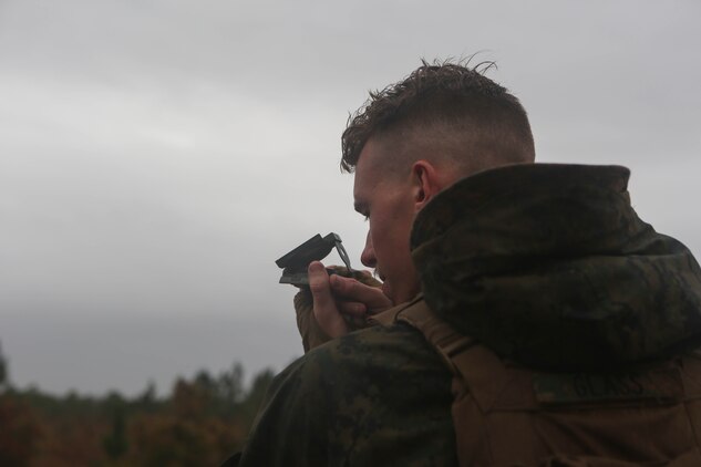 A Marine with 3rd Battalion, 6th Marine Regiment, looks a through compass during a 60mm mortar live-fire range at Marine Corps Base Camp Lejeune, N.C., Nov. 19, 2015. Despite heavy rainfall and wind, the Marines completed the mortar shoot in order to retain and refine their skills with the weapons system and prove they could complete a fire mission under any conditions. 