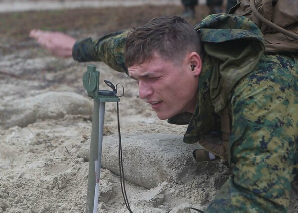 A Marine with 3rd Battalion, 6th Marine Regiment, looks a through compass during a 60mm mortar live-fire range at Marine Corps Base Camp Lejeune, N.C., Nov. 19, 2015. Despite heavy rainfall and wind, the Marines completed the mortar shoot in order to retain and refine their skills with the weapons system and prove they could complete a fire mission under any conditions. 