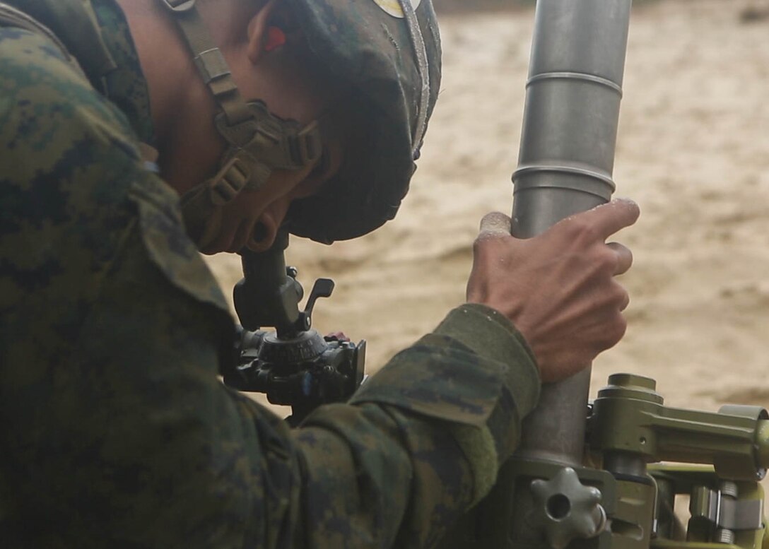 A Marine with 3rd Battalion, 6th Marine Regiment, makes adjustments to the fire direction of the 60mm mortar during a live-fire training range at Marine Corps Base Camp Lejeune, N.C., Nov. 19, 2015. Despite heavy rainfall and wind, the Marines completed the mortar shoot in order to retain and refine their skills with the weapons system and prove they could complete a fire mission under any conditions. 