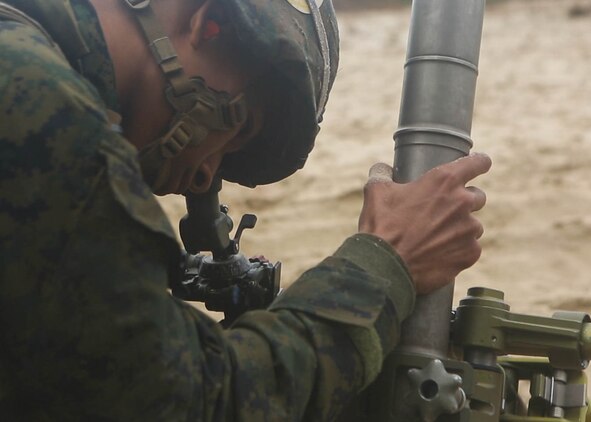 A Marine with 3rd Battalion, 6th Marine Regiment, makes adjustments to the fire direction of the 60mm mortar during a live-fire training range at Marine Corps Base Camp Lejeune, N.C., Nov. 19, 2015. Despite heavy rainfall and wind, the Marines completed the mortar shoot in order to retain and refine their skills with the weapons system and prove they could complete a fire mission under any conditions. 