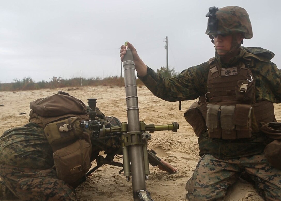 Marine with 3rd Battalion, 6th Marine Regiment, drop a round into a 60mm mortar during a live-fire training range at Marine Corps Base Camp Lejeune, N.C., Nov. 19, 2015. Despite heavy rainfall and wind, the Marines completed the mortar shoot in order to retain and refine their skills with the weapons system and prove they could complete a fire mission under any conditions.