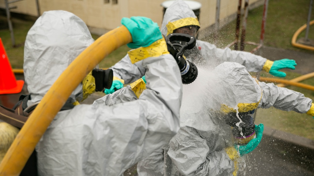 Service members and firefighters practice decontaminating each other during the Hazardous Material Awareness and Operations course at Marine Corps Air Station Iwakuni, Japan, Nov. 19, 2015. This weeklong course gives participants the necessary knowledge and experience they need to be recognized as first responders in a HazMat incident. 