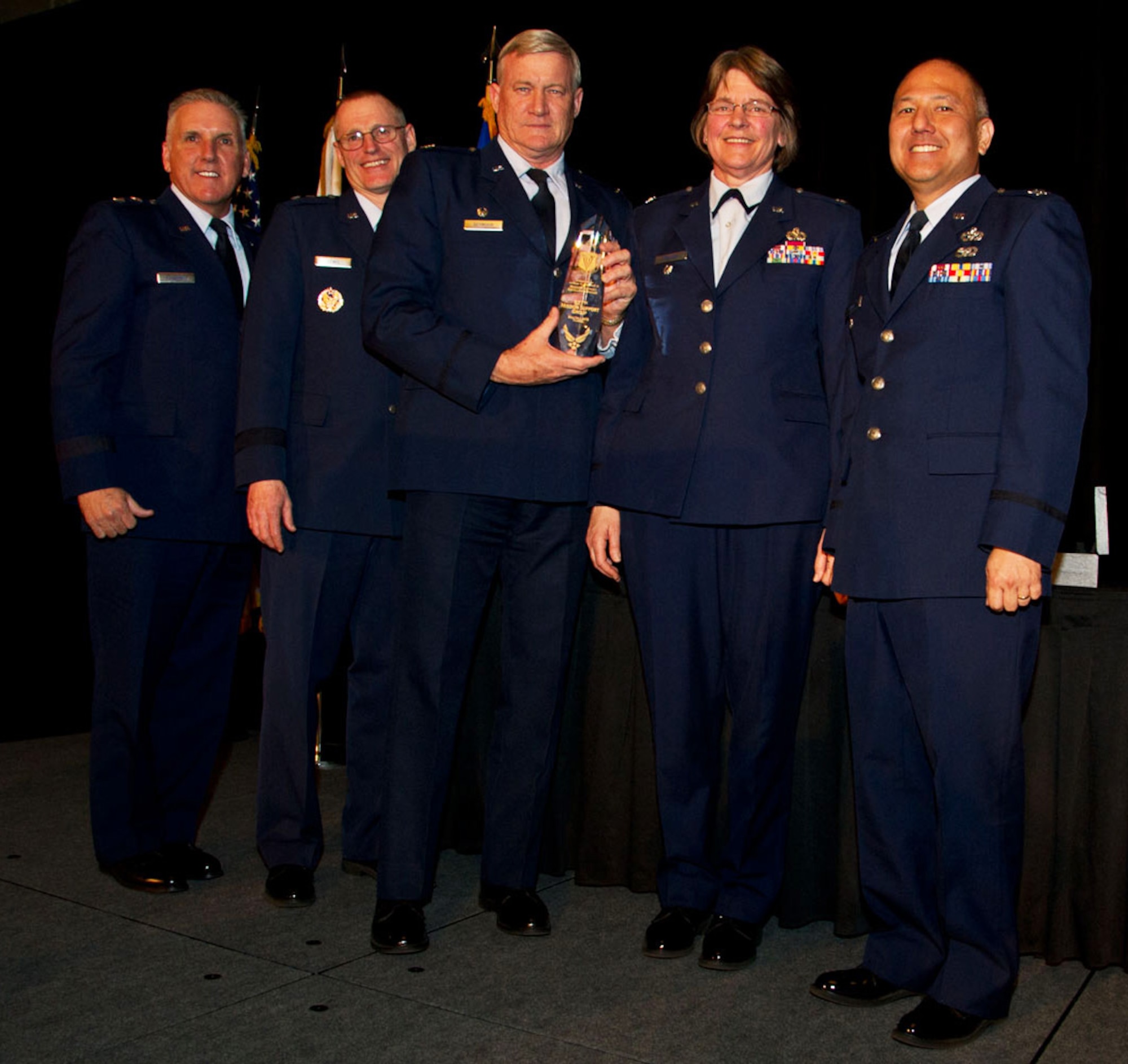 The 927th Mission Support Group commander accepts the TSgt Anthony C. Campbell Jr. Trophy during the 2015 Raincross Awards Dinner on November 19, 2015. The Raincross Awards Dinner is an annual event sponsored by the Greater Riverside Chamber of Commerce designed to recognize the outstanding performance of 4th Air Force units. From left to right: Maj. Gen. John C. Flournoy, Maj. Gen. Kenneth D. Lewis Jr., Col. Dennis L. Seymour, Col. Nancy J. Brooks, Col. Randall I Honke. (U.S. Air Force photo by Senior Master Sergeant Kieth Baxter)