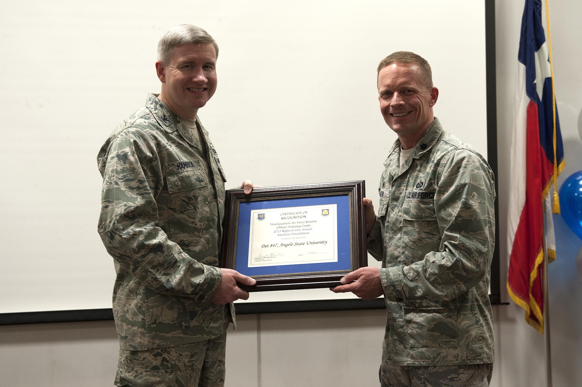 U.S. Air Force Col. Terry J. Hamrick Jr., 17th Training Wing Vice Commander, hands the 2015 Right of Line Award for Detachment 847 to Lt. Col. Scott M. Partin, Angelo State University Department Head and Professor of Aerospace Studies, at Angelo State University, San Angelo, Texas, Nov. 18, 2015. The detachment holds AF ROTC for college students or enlisted personnel that wish to commission. (U.S. Air Force photo by Airman 1st Class Caelynn Ferguson/Released)
