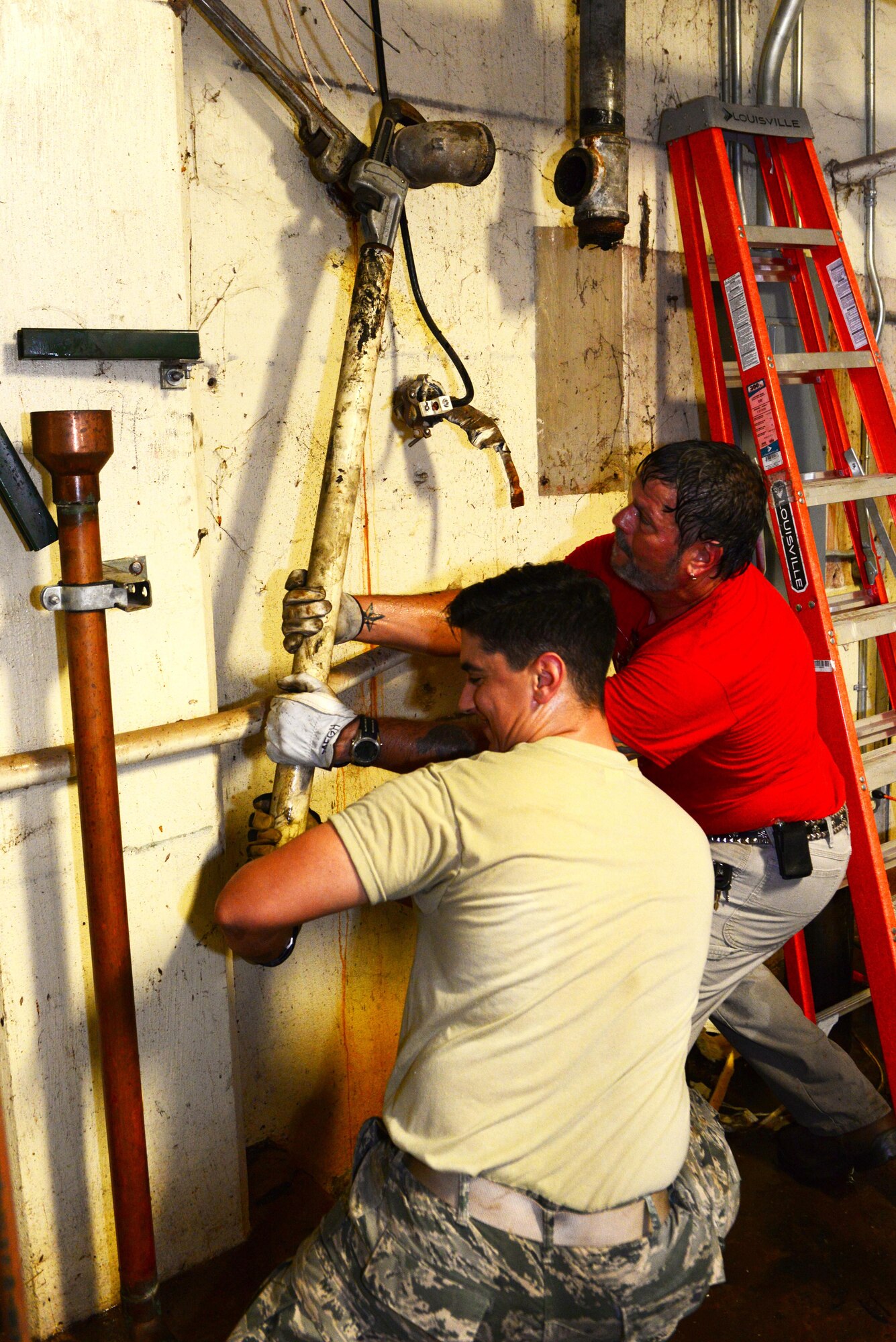 Airman 1st Class Michael Naughton, 2nd Civil Engineer Squadron water and fuel systems apprentice, left, and Glenn Hannis, 2nd CES water and fuel systems plumber, use leverage to unscrew old water piping for the Air Force Global Strike building at Barksdale Air Force Base, La., Nov. 17, 2015. Rusted out and corrosive piping is dangerous because the leaks can cause damage to the infrastructure of buildings as well as waste water. (U.S. Air Force Photo/Airman 1st Class Luke Hill)