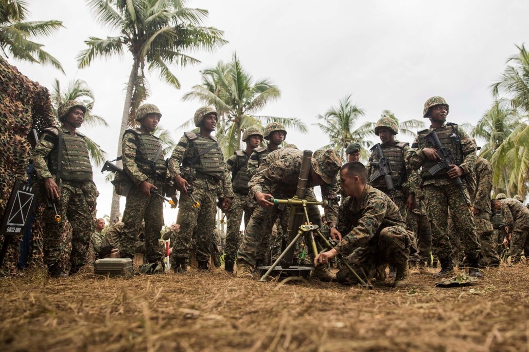 TANDUO BEACH, Malaysia (Nov. 10, 2015) U.S. Marines Lance Cpl. Maurice Gardner, left, and Lance Cpl. Gary Gomez demonstrate how to operate an M224A1 60 mm mortar system to Malaysian soldiers during Malaysia-United States Amphibious Exercise 2015. Gardner and Gomez are mortar men with Kilo Company, Battalion Landing Team 3rd Battalion, 1st Marine Regiment, 15th Marine Expeditionary Unit. During MALUS AMPHEX 15, Marines with the 15th MEU and Malaysian soldiers exchanged infantry weapon capabilities and tactics. The purpose of the exercise was to strengthen military cooperation in the planning and execution of amphibious operations between Malaysian armed forces and U.S. Marines. The 15th MEU is currently deployed in the Indo-Asia-Pacific region to promote regional stability and security in the U.S. 7th Fleet area of operations. (U.S. Marine Corps photo by Sgt. Emmanuel Ramos/Released)