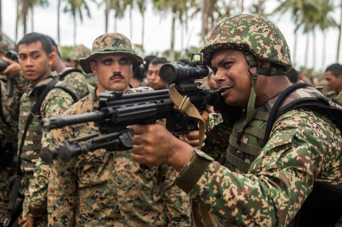 TANDUO BEACH, Malaysia (Nov. 10, 2015) U.S. Marine Cpl. Paul Kainz, left, demonstrates how to operate the M27 infantry automatic rifle to a Malaysian soldier during Malaysia-United States Amphibious Exercise 2015. Kainz is an automatic rifleman with Kilo Company, Battalion Landing Team 3rd Battalion, 1st Marine Regiment, 15th Marine Expeditionary Unit. During MALUS AMPHEX 15, Marines with the 15th MEU and Malaysian soldiers exchanged infantry weapon capabilities and tactics. The purpose of the exercise was to strengthen military cooperation in the planning and execution of amphibious operations between Malaysian armed forces and U.S. Marines. The 15th MEU is currently deployed in the Indo-Asia-Pacific region to promote regional stability and security in the U.S. 7th Fleet area of operations. (U.S. Marine Corps photo by Sgt. Emmanuel Ramos/Released)