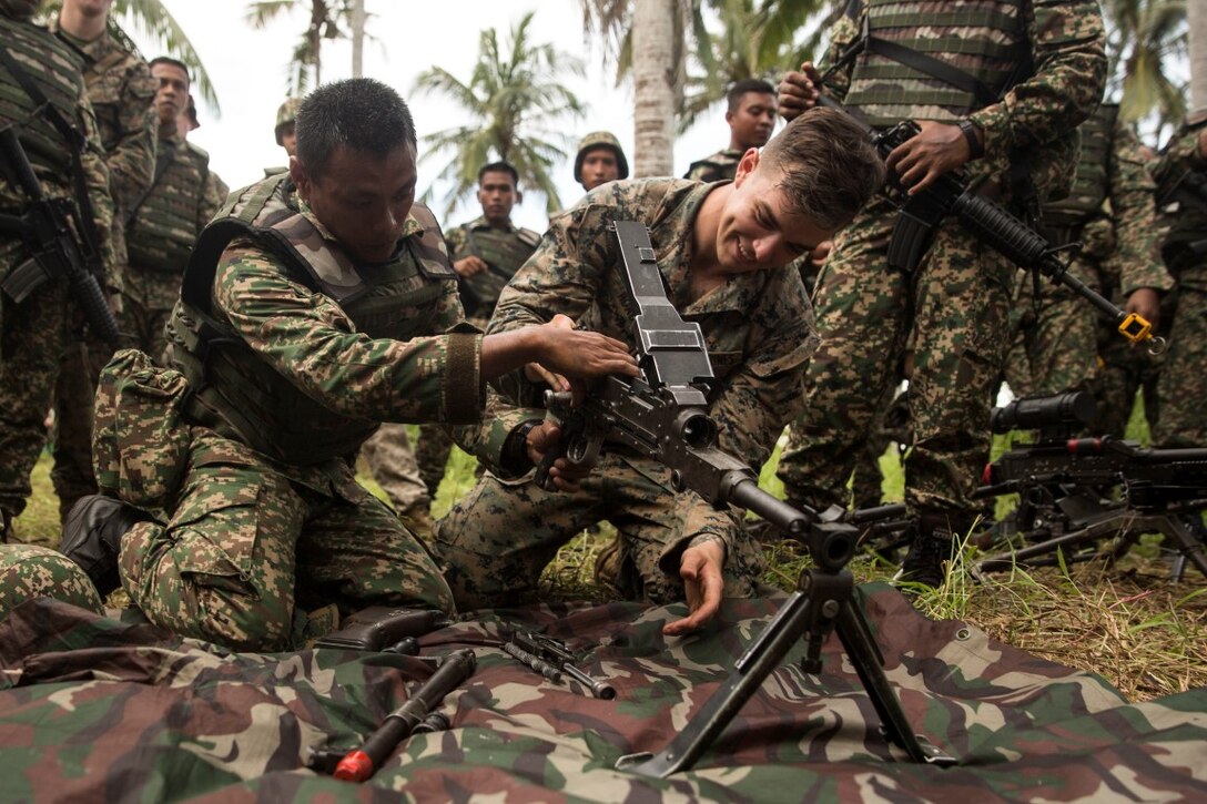 TANDUO BEACH, Malaysia (Nov. 10, 2015) U.S. Marine Lance Cpl. Cody Hoag learns how to disassemble a machine gun from Malaysian soldiers during Malaysia-United States Amphibious Exercise 2015. Hoag is a machine gunner with Kilo Company, Battalion Landing Team 3rd Battalion, 1st Marine Regiment, 15th Marine Expeditionary Unit. During MALUS AMPHEX 15, Marines with the 15th MEU and Malaysian soldiers exchanged infantry weapon capabilities and tactics. The purpose of the exercise was to strengthen military cooperation in the planning and execution of amphibious operations between Malaysian armed forces and U.S. Marines. The 15th MEU is currently deployed in the Indo-Asia-Pacific region to promote regional stability and security in the U.S. 7th Fleet area of operations. (U.S. Marine Corps photo by Sgt. Emmanuel Ramos/Released)
