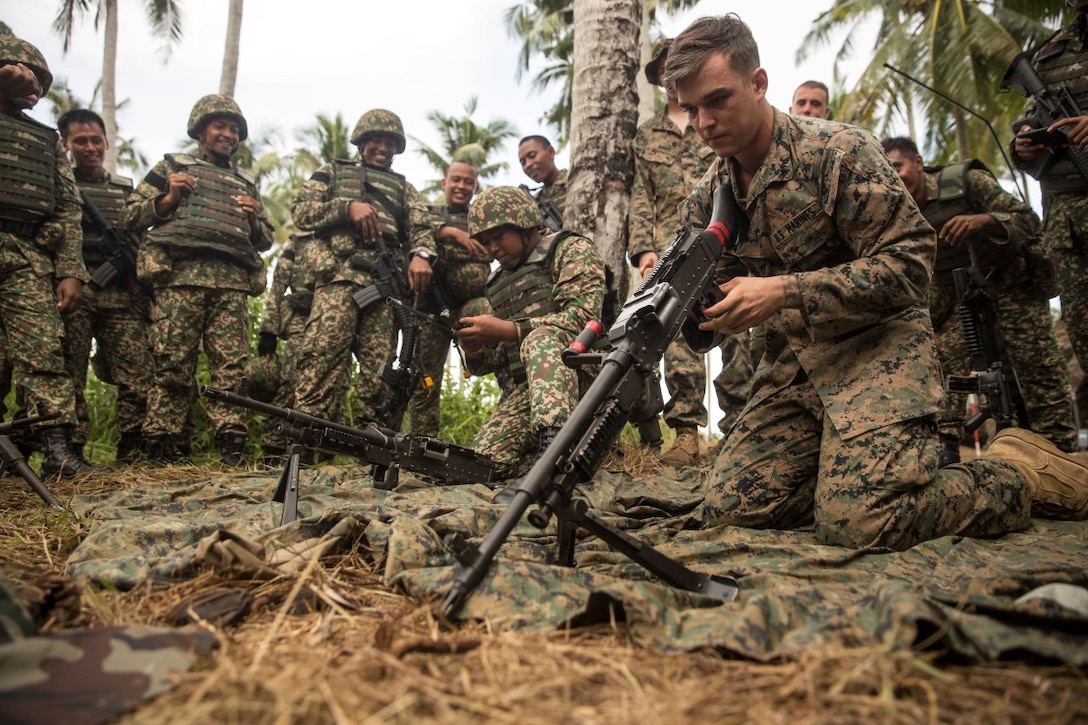 TANDUO BEACH, Malaysia (Nov. 10, 2015) U.S. Marine Lance Cpl. Cody Hoag learns how to disassemble a machine gun from Malaysian soldiers during Malaysia-United States Amphibious Exercise 2015. Hoag is a machine gunner with Kilo Company, Battalion Landing Team 3rd Battalion, 1st Marine Regiment, 15th Marine Expeditionary Unit. During MALUS AMPHEX 15, Marines with the 15th MEU and Malaysian soldiers exchanged infantry weapon capabilities and tactics. The purpose of the exercise was to strengthen military cooperation in the planning and execution of amphibious operations between Malaysian armed forces and U.S. Marines. The 15th MEU is currently deployed in the Indo-Asia-Pacific region to promote regional stability and security in the U.S. 7th Fleet area of operations. (U.S. Marine Corps photo by Sgt. Emmanuel Ramos/Released)