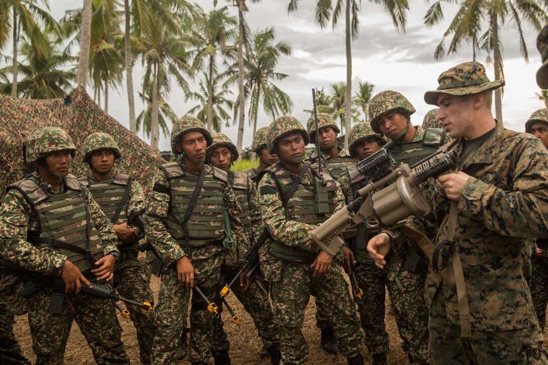 TANDUO BEACH, Malaysia (Nov. 10, 2015) U.S. Marine Lance Cpl. Austin De La Cruz demonstrates how to operate the M32 semi-automatic grenade launcher to Malaysian soldiers during Malaysia-United States Amphibious Exercise 2015. De La Cruz is a rifleman with Kilo Company, Battalion Landing Team 3rd Battalion, 1st Marine Regiment, 15th Marine Expeditionary Unit. During MALUS AMPHEX 15, Marines with the 15th MEU and Malaysian soldiers exchanged infantry weapon capabilities and tactics. The purpose of the exercise was to strengthen military cooperation in the planning and execution of amphibious operations between Malaysian armed forces and U.S. Marines. The 15th MEU is currently deployed in the Indo-Asia-Pacific region to promote regional stability and security in the U.S. 7th Fleet area of operations. (U.S. Marine Corps photo by Sgt. Emmanuel Ramos/Released)