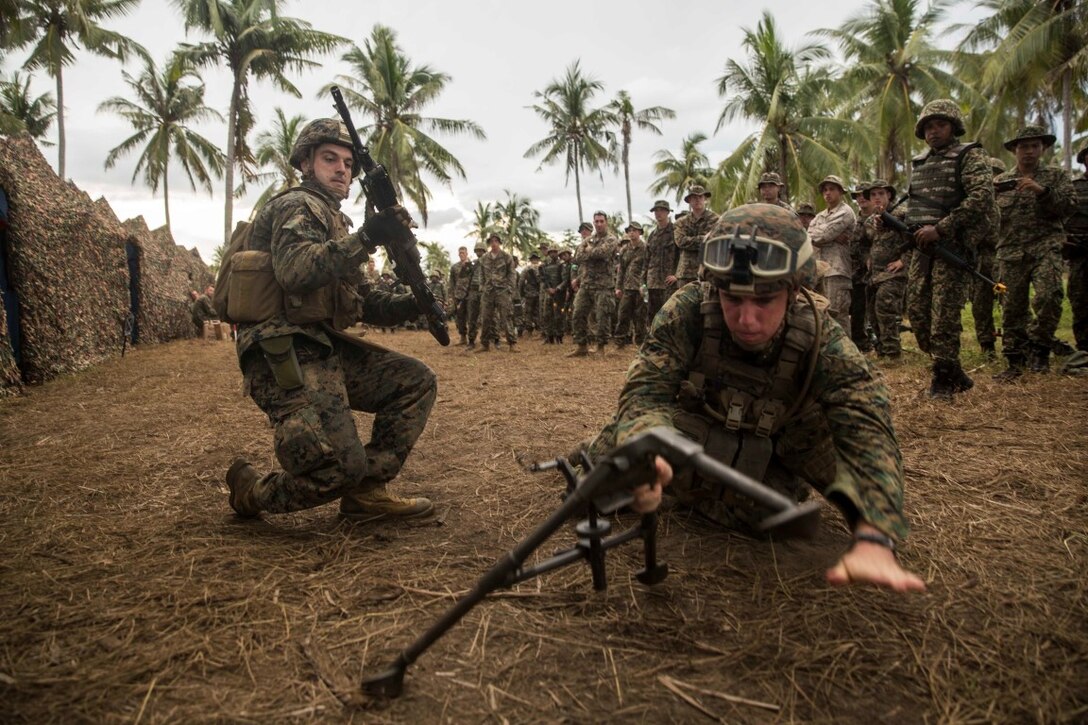 TANDUO BEACH, Malaysia (Nov. 10, 2015) U.S. Marines Lance Cpl. Jesse Haynes, left, and Lance Cpl. Nicolas Biglione demonstrate how to operate the M240B machine gun to Malaysian soldiers during Malaysia-United States Amphibious Exercise 2015. Haynes and Biglione are both machine gunners with Kilo Company, Battalion Landing Team 3rd Battalion, 1st Marine Regiment, 15th Marine Expeditionary Unit. During MALUS AMPHEX 15, Marines with the 15th MEU and Malaysian soldiers exchanged infantry weapon capabilities and tactics. The purpose of the exercise was to strengthen military cooperation in the planning and execution of amphibious operations between Malaysian armed forces and U.S. Marines. The 15th MEU is currently deployed in the Indo-Asia-Pacific region to promote regional stability and security in the U.S. 7th Fleet area of operations. (U.S. Marine Corps photo by Sgt. Emmanuel Ramos/Released)