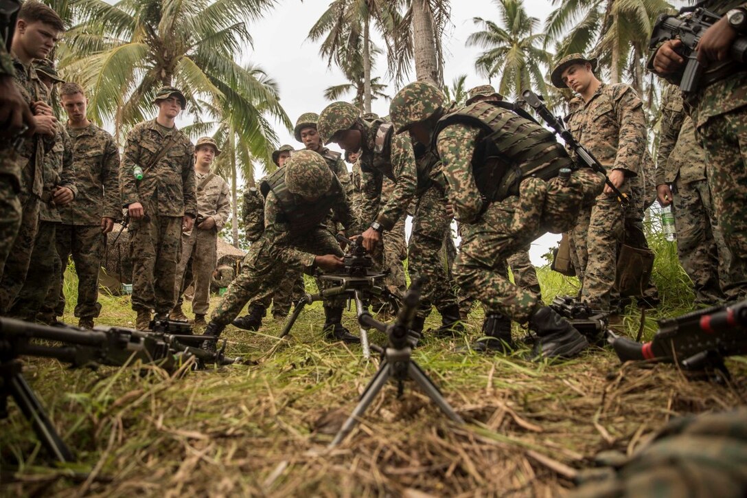 TANDUO BEACH, Malaysia (Nov. 10, 2015) Malaysian soldiers demonstrate to U.S. Marines with Kilo Company, Battalion Landing Team 3rd Battalion, 1st Marine Regiment, 15th Marine Expeditionary Unit, how they operate their machine gun during Malaysia-United States Amphibious Exercise 2015. During MALUS AMPHEX 15, Marines with the 15th MEU and Malaysian soldiers exchanged infantry weapon capabilities and tactics. The purpose of the exercise was to strengthen military cooperation in the planning and execution of amphibious operations between Malaysian armed forces and U.S. Marines. The 15th MEU is currently deployed in the Indo-Asia-Pacific region to promote regional stability and security in the U.S. 7th Fleet area of operations. (U.S. Marine Corps photo by Sgt. Emmanuel Ramos/Released)