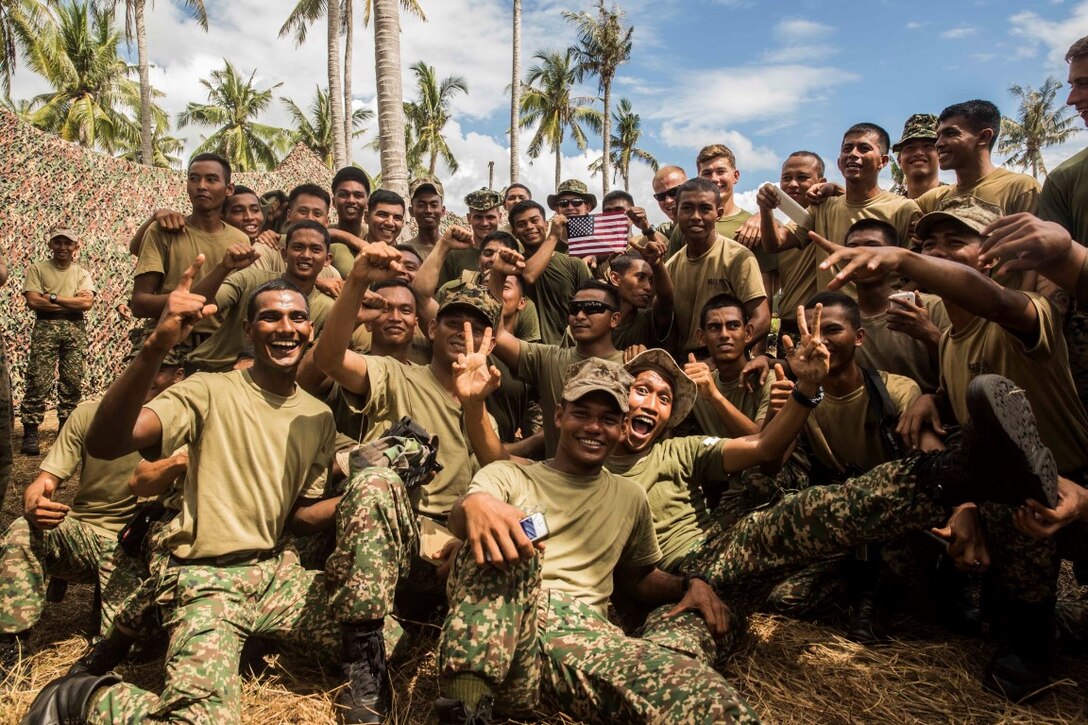 TANDUO BEACH, Malaysia (Nov. 12, 2015) U.S. Marines with Kilo Company, Battalion Landing Team 3rd Battalion, 1st Marine Regiment, 15th Marine Expeditionary Unit, and Malaysian soldiers pose for photographs  during Malaysia-United States Amphibious Exercise 2015. During the integration, Marines and soldiers learned about each other’s culture, country, military service, exchanged personal gifts, and ended with a barbeque. The purpose of the exercise was to strengthen military cooperation in the planning and execution of amphibious operations between Malaysian armed forces and U.S. Marines. The 15th MEU is currently deployed in the Indo-Asia-Pacific region to promote regional stability and security in the U.S. 7th Fleet area of operations. (U.S. Marine Corps photo by Sgt. Emmanuel Ramos/Released)