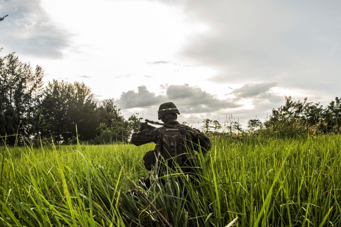 TANDUO BEACH, Malaysia (Nov. 11, 2015) U.S. Marine Lance Cpl. Joseph Aspiras moves through tall grass while training with Malaysian soldiers on amphibious operations during Malaysia-United States Amphibious Exercise 2015. Aspiras is a rifleman with Kilo Company, Battalion Landing Team 3rd Battalion, 1st Marine Regiment, 15th Marine Expeditionary Unit. During MALUS AMPHEX 15, Marine fire teams paired with a squad of Malaysian soldiers and rehearsed amphibious assault tactics. The purpose of the exercise was to strengthen military cooperation in the planning and execution of amphibious operations between Malaysian armed forces and U.S. Marines. The 15th MEU is currently deployed in the Indo-Asia-Pacific region to promote regional stability and security in the U.S. 7th Fleet area of operations. (U.S. Marine Corps photo by Sgt. Emmanuel Ramos/Released)
