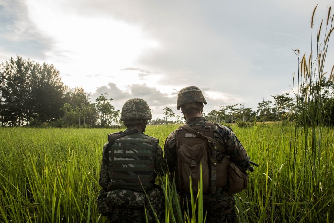 TANDUO BEACH, Malaysia (Nov. 11, 2015) U.S. Marine Cpl. Keven Ta works with a Malaysian soldier on amphibious operations during Malaysia-United States Amphibious Exercise 2015. Ta is a team leader with Kilo Company, Battalion Landing Team 3rd Battalion, 1st Marine Regiment, 15th Marine Expeditionary Unit. During MALUS AMPHEX 15, Marine fire teams paired with a squad of Malaysian soldiers and rehearsed amphibious assault tactics. The purpose of the exercise was to strengthen military cooperation in the planning and execution of amphibious operations between Malaysian armed forces and U.S. Marines. The 15th MEU is currently deployed in the Indo-Asia-Pacific region to promote regional stability and security in the U.S. 7th Fleet area of operations. (U.S. Marine Corps photo by Sgt. Emmanuel Ramos/Released)