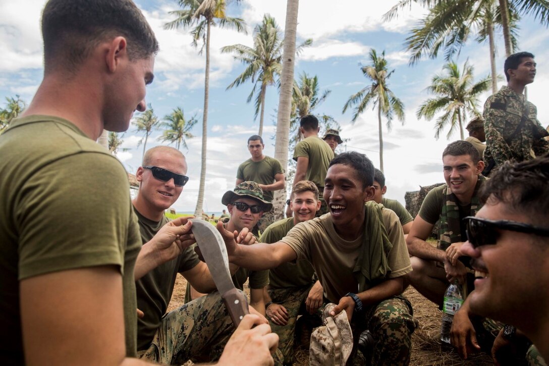 TANDUO BEACH, Malaysia (Nov. 12, 2015) U.S. Marines with Kilo Company, Battalion Landing Team 3rd Battalion, 1st Marine Regiment, 15th Marine Expeditionary Unit, and Malaysian soldiers learn from each other during Malaysia-United States Amphibious Exercise 2015. During the integration, Marines and soldiers learned about each other’s culture, country, military service, exchanged personal gifts, and ended with a barbeque. The purpose of the exercise was to strengthen military cooperation in the planning and execution of amphibious operations between Malaysian armed forces and U.S. Marines. The 15th MEU is currently deployed in the Indo-Asia-Pacific region to promote regional stability and security in the U.S. 7th Fleet area of operations. (U.S. Marine Corps photo by Sgt. Emmanuel Ramos/Released)