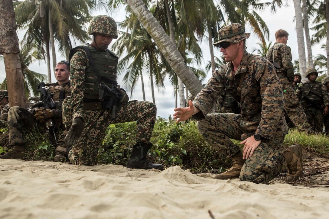 TANDUO BEACH, Malaysia (Nov. 11, 2015) U.S. Marine 1st Lt. Erik Glynn discusses troop movements with a Malaysian army platoon commander prior to rehearsing amphibious operations during Malaysia-United States Amphibious Exercise 2015. Glynn is a platoon commander with Kilo Company, Battalion Landing Team 3rd Battalion, 1st Marine Regiment, 15th Marine Expeditionary Unit. During MALUS AMPHEX 15, Marine fire teams paired with a squad of Malaysian soldiers and rehearsed amphibious assault tactics. The purpose of the exercise was to strengthen military cooperation in the planning and execution of amphibious operations between Malaysian armed forces and U.S. Marines. The 15th MEU is currently deployed in the Indo-Asia-Pacific region to promote regional stability and security in the U.S. 7th Fleet area of operations. (U.S. Marine Corps photo by Sgt. Emmanuel Ramos/Released)