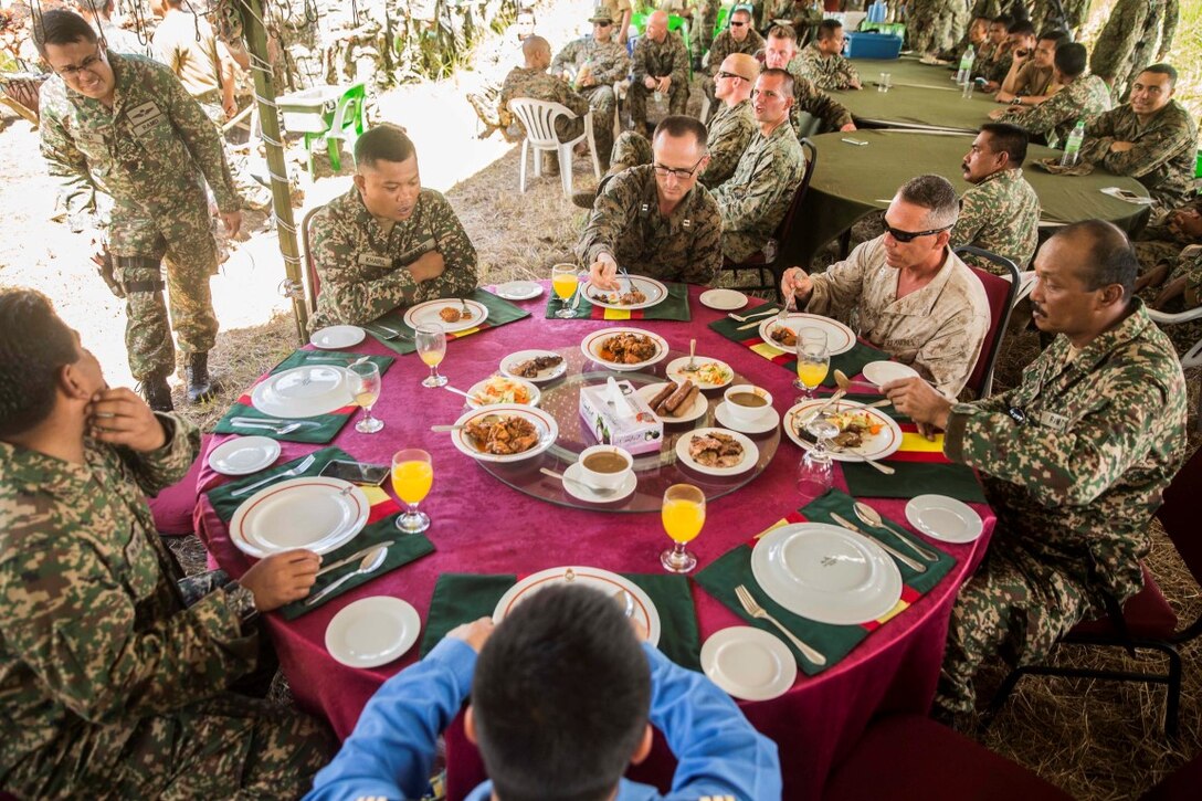 TANDUO BEACH, Malaysia (Nov. 12, 2015) U.S. Marines with Kilo Company, Battalion Landing Team 3rd Battalion, 1st Marine Regiment, 15th Marine Expeditionary Unit, and Malaysian soldiers have a meal together during Malaysia-United States Amphibious Exercise 2015. During the integration, Marines and soldiers learned about each other’s culture, country, military service, exchanged personal gifts, and ended with a barbeque. The purpose of the exercise was to strengthen military cooperation in the planning and execution of amphibious operations between Malaysian armed forces and U.S. Marines. The 15th MEU is currently deployed in the Indo-Asia-Pacific region to promote regional stability and security in the U.S. 7th Fleet area of operations. (U.S. Marine Corps photo by Sgt. Emmanuel Ramos/Released)