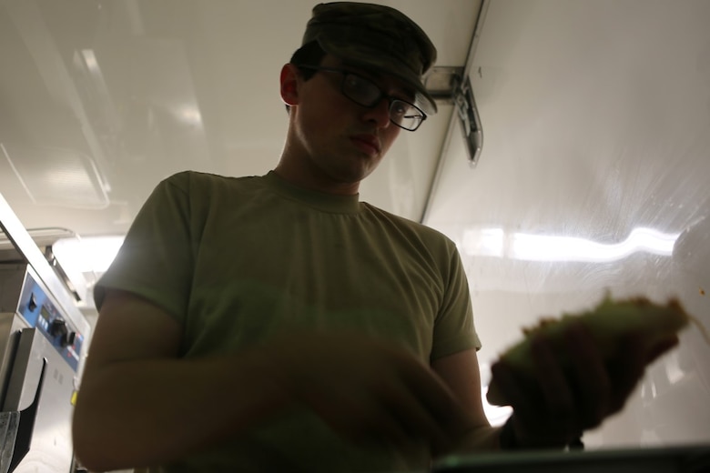U.S. Army Spc. Dustin Freeman, a food services specialist with Headquarter and Headquarters Company, Special Troops Battalion, Sustainment Brigade, 1st Infantry Division, prepares a meal at evening chow for services members at Al Taqaddum Air Base, Iraq, Nov. 7, 2015. The food service members will continue to wake before the sun and toil into the late hours of the night to continue to provide support to U.S. and coalition forces in their day-to-day operations in support of Combined Joint Task Force-Operation Inherent Resolve.  (U.S. Marine Corps photo by Sgt. Owen Kimbrel)