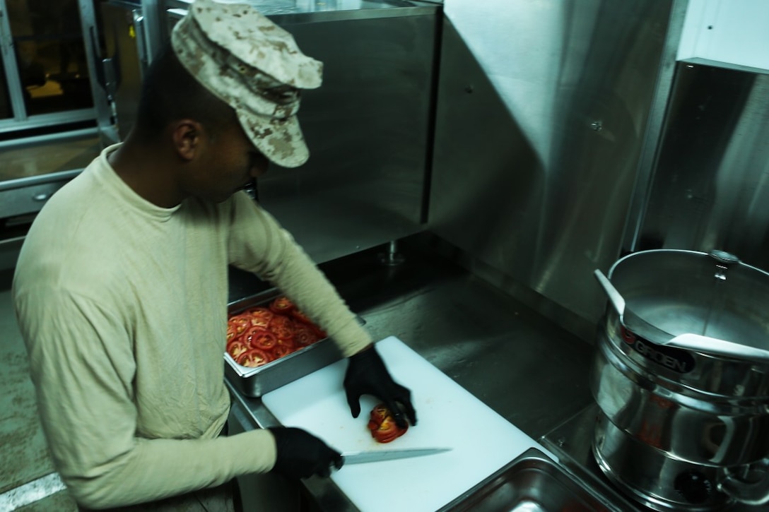 U.S. Marine Cpl. William Yaporagiles, a food services specialist with Combat Logistics Battalion 1, Special Purpose Marine Air Ground Task Force-Crisis Response-Central Command, slices tomatoes in preparation for evening chow time at Al Taqaddum Air Base, Iraq, Nov. 7, 2015. Yaporagiles spends his days cooking and serving U.S. and coalition forces at Camp Manion in support of Combined Joint Task Force-Operation Inherent Resolve. (U.S. Marine Corps photo by Sgt. Owen Kimbrel)