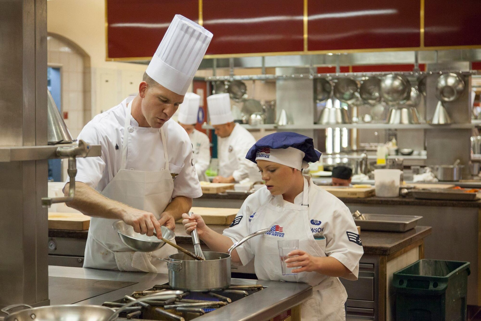 Marine Sgt. Austin Nelson and Senior Airman Chelsea Lawson collaborate during a cooking session during the Armed Forces Forum for Excellence at the Culinary Institute of America at Greystone in St. Helena, California. (Air Force courtesy photo/Released)