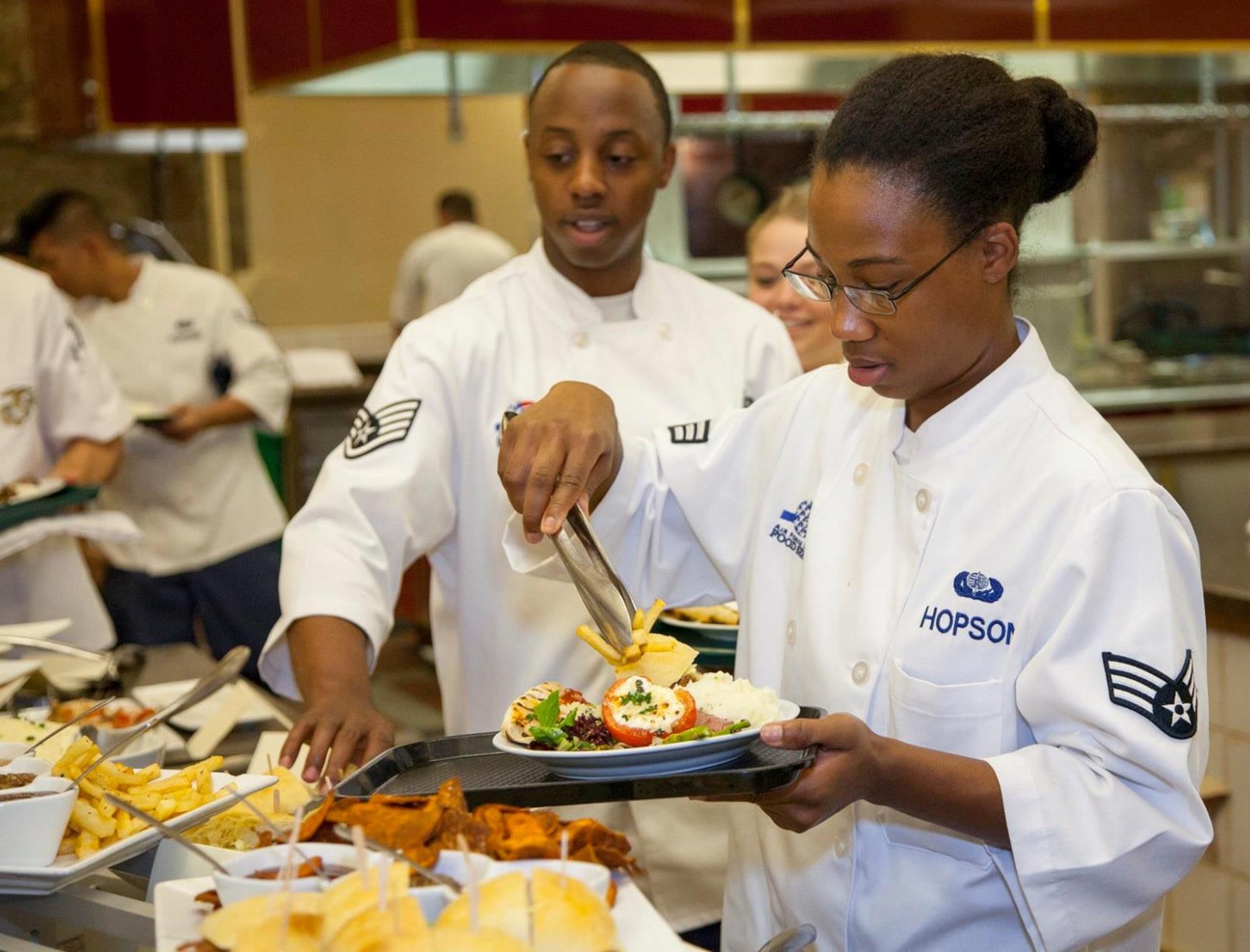 Staff Sgt. Reginald Brown and Airman 1st Class Skiilar Hopson put the finishing touches on a plate during a cooking session during the Armed Forces Forum for Excellence at the Culinary Institute of America at Greystone in St. Helena, California. (Air Force courtesy photo/Released)