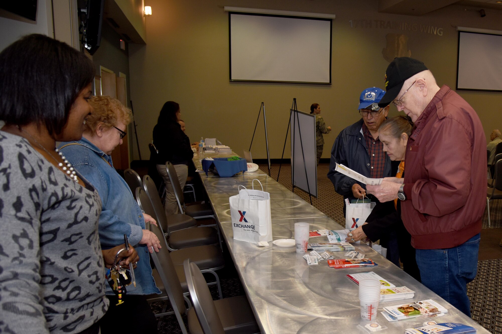 U.S. Air Force Col. Michael L. Downs, 17th Training Wing Commander, speaks with retired U.S. Army Sgt. 1st Class Bill Norvell, Retiree Appreciation Day participant, during the Retiree Appreciation Day in the Event Center on Goodfellow Air Force Base, Texas, Nov. 19, 2015. During Retiree Appreciation Day, retirees could get shots at the Ross Clinic, update their ID cards and get a free lunch at the Crossroads Student Center. (U.S. Air Force photo by Senior Airman Joshua Edwards/Released)