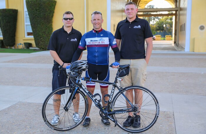 Chief Warrant Officer 3 William P. Tinney, ordnance officer, armory, Headquarters and Service Battalion, poses with his team after a 240-mile bike ride ending at Marine Corps Recruit Depot San Diego, Nov. 10. Sgt. Jeffrey R. Trumbo (left), floor chief, armory, HQSVCBN, MCRD San Diego, and Cpl. Jeremy S. Elston, armorer, armory, HQSVCBN, MCRD San Diego, drove alongside Tinney to guide him track his eating and hydration.
