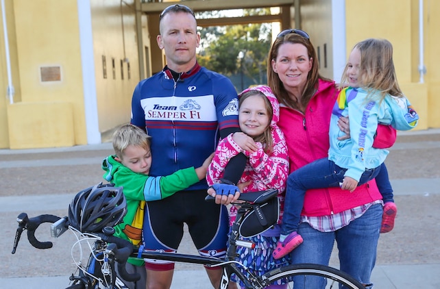 Chief Warrant Officer 3 William P. Tinney, ordnance officer, armory, Headquarters and Service Battalion, poses with his family after a 240-mile bike ride that ended at Marine Corps Recruit Depot San Diego, Nov. 10. Tinney completed the ride in approximately 15 hours and faced challenges such as traffic and technology glitches during the ride.
