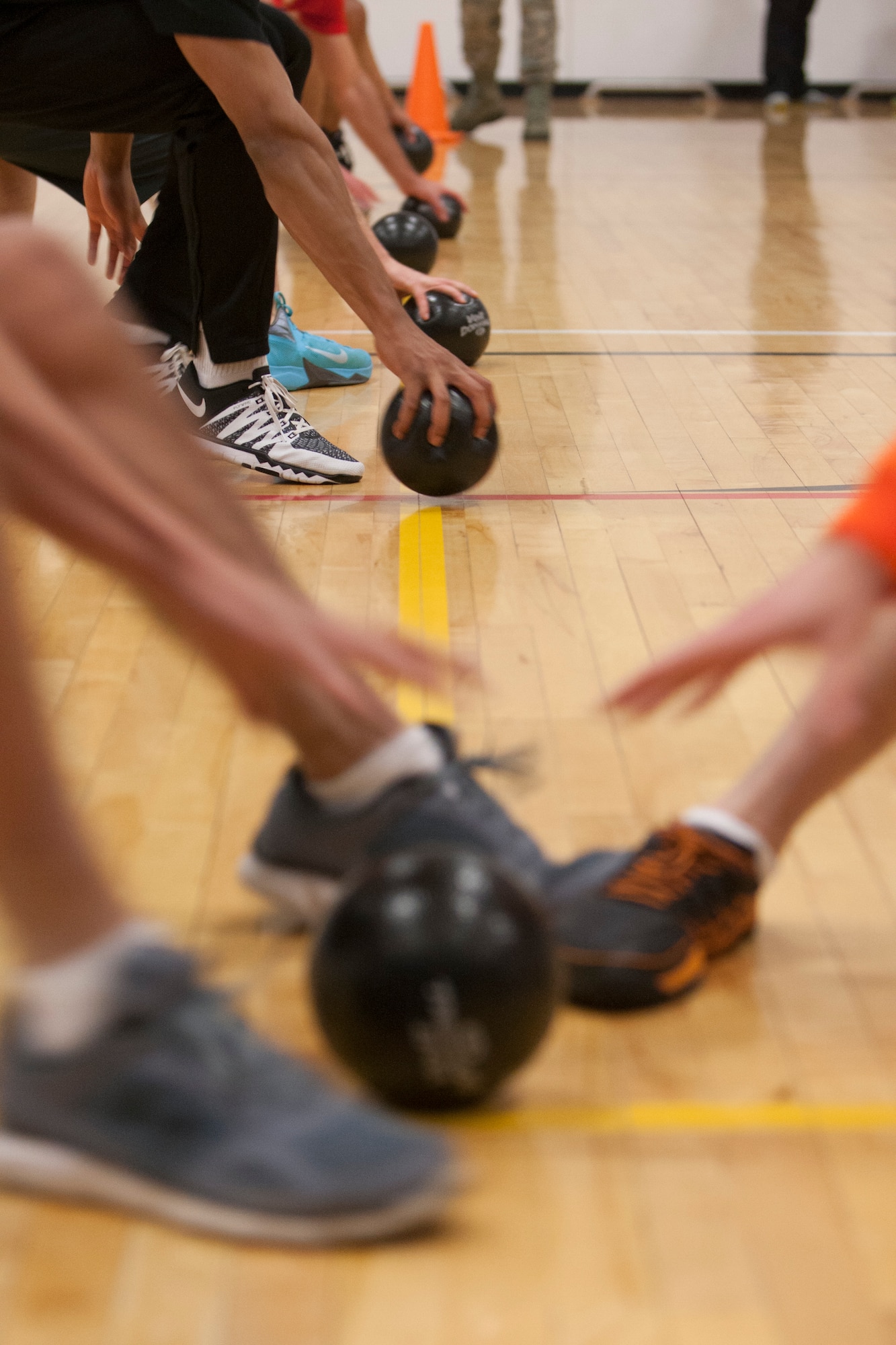 Participants rush to grab a dodgeball during a dodgeball tournament at the Freedom Hall Fitness Center on F.E. Warren Air Force Base, Nov. 20, 2015. The winning team was the Fitness center staff members. (U.S. Air Force photo by Lan Kim)

