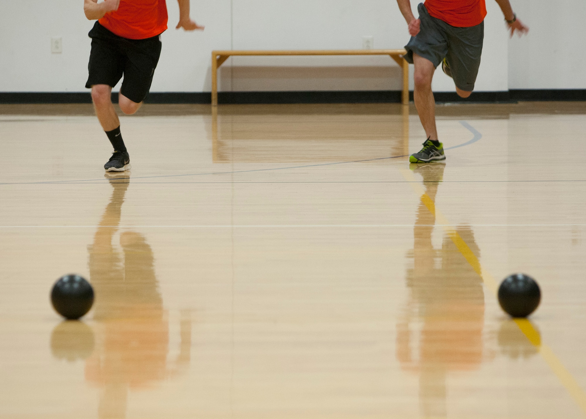 Derek Taylor and Patrick Stark, 90th Contracting Squadron, rush to grab dodgeballs before the opposing team Nov. 20, 2015, during a dodgeball tournament at the Freedom Hall Fitness Center on F.E. Warren Air Force Base. A total of 23 teams representing various units across the 90th Missile Wing competed in the single-elimination tournament. (U.S. Air Force photo by Lan Kim)
