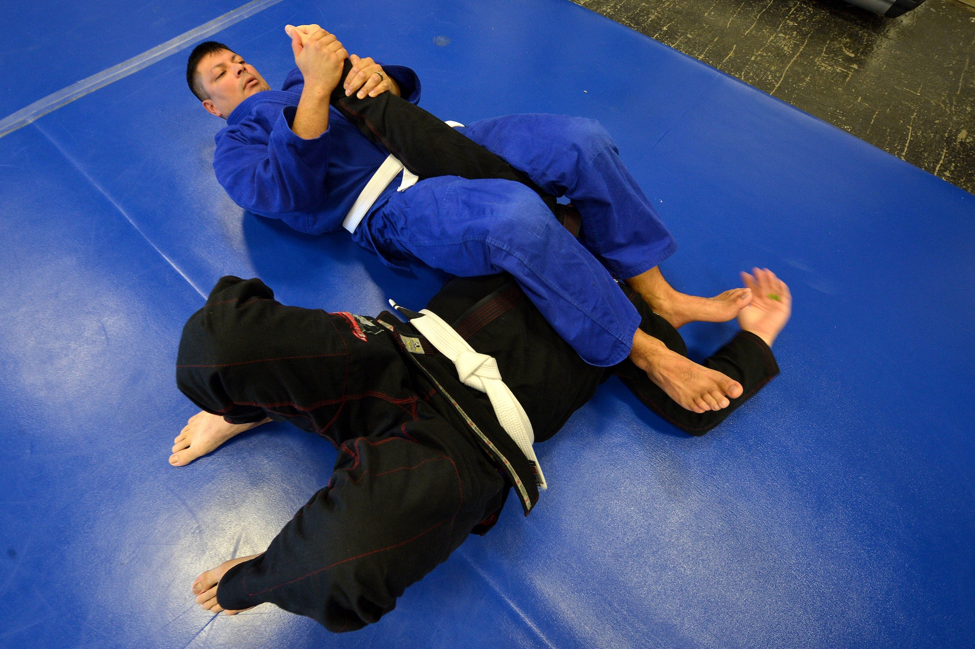 Two students of the Combatives House jiu-jitsu program practice their skills with the arm bar at Shaw Air Force Base, S.C., Nov. 14, 2015. The facility ran by volunteers offer free jiu-jitsu, boxing, cross-fit, extreme fitness classes, and Level I and Level II Army Combatives training. (U.S. Air Force photo by Senior Airman Diana M. Cossaboom)
