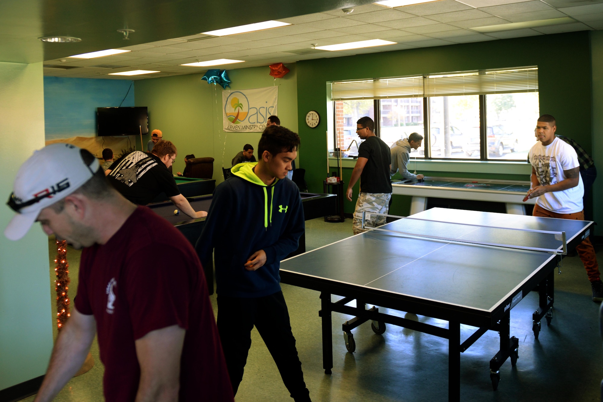 Team Seymour Airmen play ping pong, billiards and other games during the grand re-opening of the Oasis Airmen Ministry Center, Nov. 21, 2015, at Seymour Johnson Air Force Base, North Carolina. During the event, Airmen were encouraged to sign up for ping pong and billiards tournament to promote healthy competition and encourage social interaction between competitors. (U.S. Air Force photo/Airman 1st Class Ashley Williamson)