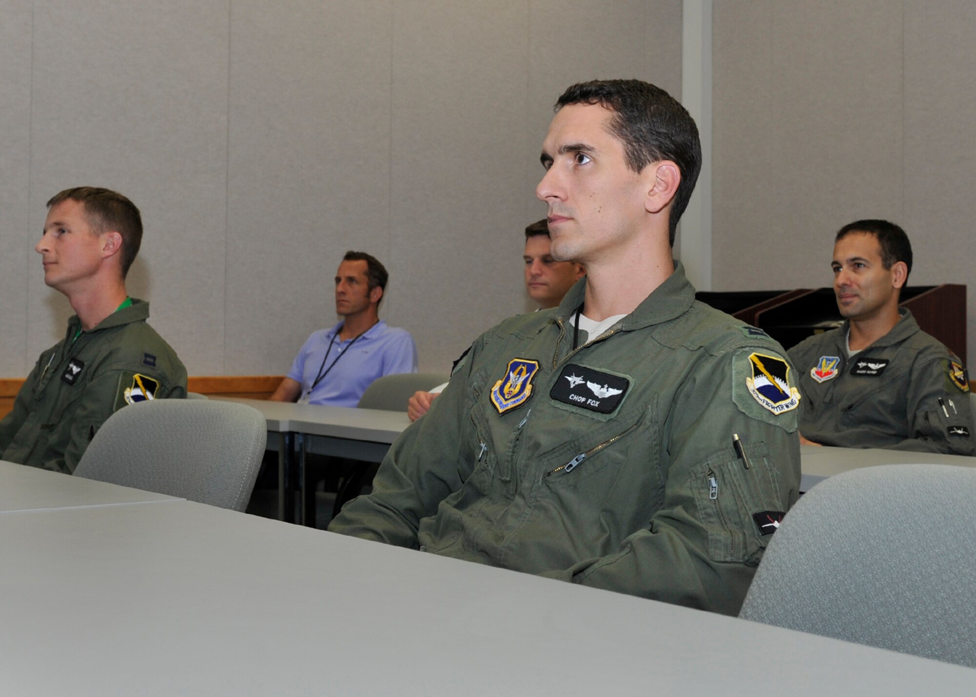 Captain Steven Fox, 301st Fighter Squadron pilot, sits in an F-22 Raptor training course Nov. 17 at the 325th Training Support Squadron. Fox is in the transition course to go from an F-16 Falcon pilot to an F-22 pilot. (U.S. Air Force photo by Senior Airman Sergio A. Gambao/Released)