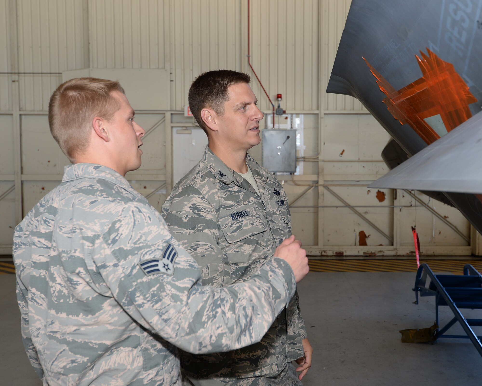 Senior Airman Hayden Johnson, low-observable aircraft maintenance technician, explains the process of applying LO coatings to Col. Joseph Kunkel, 325th Fighter Wing vice commander.  The coatings and molds used assist in the F-22s combat performance during missions, but require consistent and professional care in order to maintain its performance. (U.S. Air Force photo by Airman 1st Class Cody R. Miller/Released)