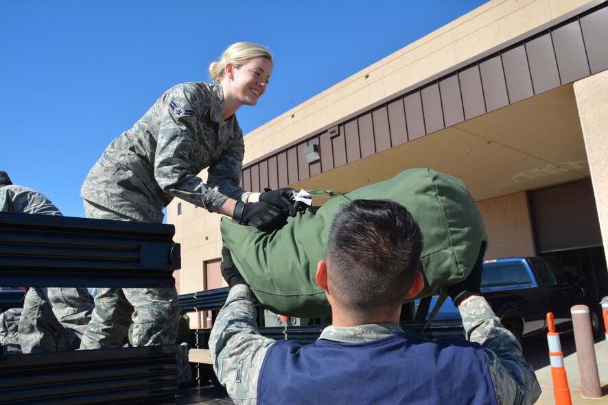 Airman First Class Taylor Zwiesler, an air transportation apprentice from the 72nd Aerial Port Squadron, grabs mobility bags from a fellow Airmen and places them on a flatbed truck to be loaded onto a C-17 Globemaster III as part of a deployment exercise conducted during the November unit training assembly at Tinker Air Force Base, Okla. Cargo is loaded onto the C-17 through a large aft door that accommodates military vehicles and palletized cargo, and has a maximum payload capacity of 170,900 pounds. (U.S. Air Force photo/Tech. Sgt. Charles Taylor)