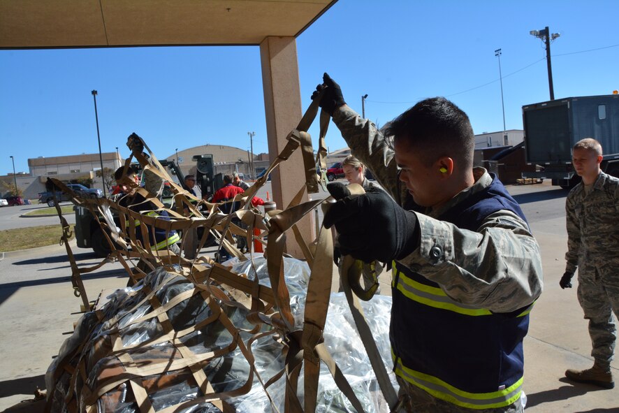 Two Airmen from the 72nd Aerial Port Squadron secure pallets of cargo during an exercise during the November unit training assembly at Tinker Air Force Base, Okla. Aerial port squadrons provide military logistical functions including processing personnel and cargo, rigging for airdrop, packing parachutes, loading equipment, preparing air cargo and load plans, loading and securing aircraft, ejecting cargo for inflight delivery, and supervising units engaged in aircraft loading and unloading operations. (U.S. Air Force photo/Tech. Sgt. Charles Taylor)