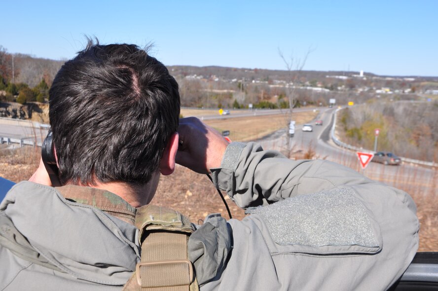 Senior Airman Phil Schneider looks over a highway south of Warsaw, Missouri as he calls in a simulated air strike to an A-10 Thunderbolt II aircraft from the 442d Fighter Wing in his field training exercise to become a JTAC on 19 November. JTACs rely on geographic markers to direct aircraft and identify targets for airstrikes. The training gives student JTACs practice in communicating with pilots in realistic missions. (U.S. Air Force photo/ Technical Sgt. Emily F. Alley)