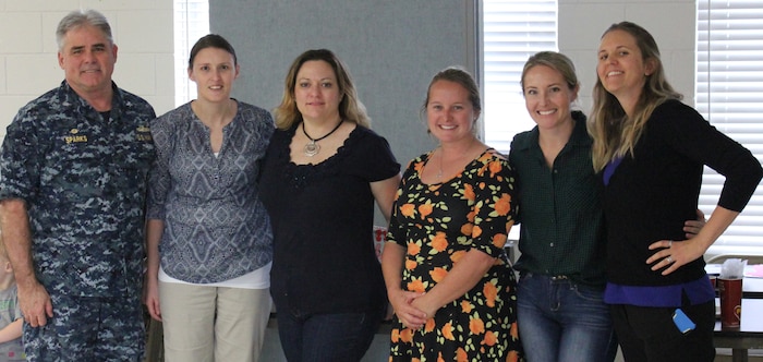 Capt. Timothy Sparks, JB Charleston deputy commander (left), poses with COMPASS course mentors (L-R), Missy Geiser, Aimee Pereira, Bridget Thresher, Liz Morrow and Kuria Spindler at the Reagan Center, JB Charleston – NWS on November 19, 2015. COMPASS, a team-mentoring program developed by Navy spouses for Navy spouses, is held several times throughout the year. The unique course helps spouses understand and meet the challenges of the Navy lifestyle. For more information on COMPASS call toll free 1-877-673-7773.  