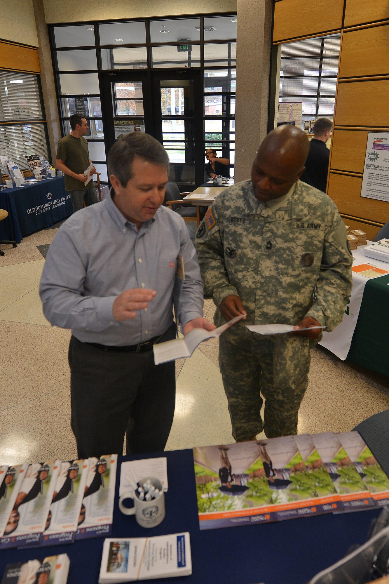 Alan Fiorello, an academic outreach manager with the University of Virginia, goes over the university’s programs and resources with U.S. Army Master Sgt. Lloyd Scott, a career counselor with U.S. Army Training and Doctrine Command, at Fort Eustis, Va., Nov. 18, 2015.  Fiorello represented one of the many schools and programs at the education and career fair held in accordance with American Education Week. (U.S. Air Force photo by Staff Sgt. Natasha Stannard)  