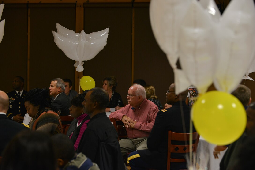Richard Reynal (center, red shirt), a Gold Star family member, listens as U .S.  Army Maj. Gen. Robert M. Dyess, the deputy director of U.S. Army Capabilities Integration Center, speaks at the 5th Annual Survivor Outreach Services’ Thanks for Giving social at Fort Eustis, Va., Nov. 19, 2015. Reynal, his wife and their grandchildren attend Gold Star events to help cope with the passing of their daughter, Sgt. Caryn Nouv. (U.S. Air Force photo by Staff Sgt. Natasha Stannard)