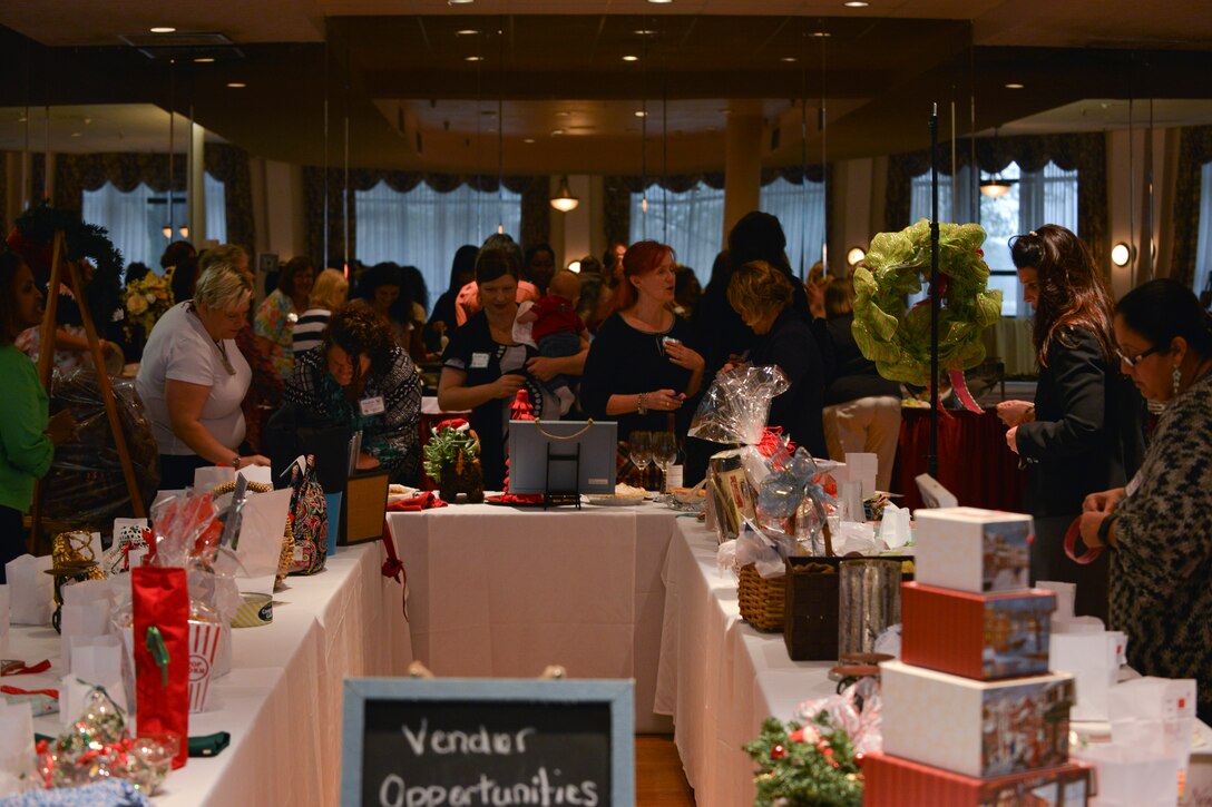 Fort Eustis’ Spouses Club (SCFE) members bid on treats and crafts during the club’s monthly luncheon at Fort Eustis, Va., Nov. 19, 2015. Proceeds from the items auctioned at the lunch will go toward grants and scholarships for U.S. Service members and their families. (U.S. Air Force photo by Staff Sgt. Natasha Stannard)