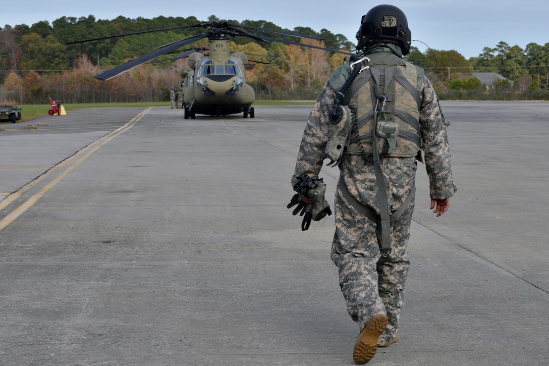 U.S. Army Reserve Staff Sgt. Job Smith, a crew member assigned to B Company, 5th Battalion (General Support) Aviation, 159th Aviation Regiment, walks towards a CH-47 Chinook at Felker Army Air Field, Fort Eustis, Va., Nov. 18, 2015. The Joint Survival Air Mask rotary wing variant, a next generation gas mask, was tested on a Chinook to determine its effectiveness. (U.S. Air Force photo by Staff Sgt. Natasha Stannard)  