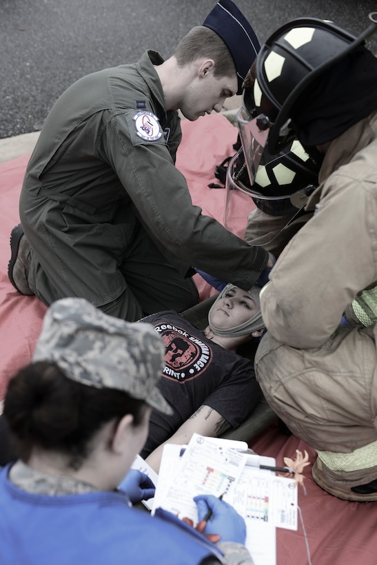 Emergency responders treat a role player victim during an active shooter exercise at Langley Air Force Base, Va., Nov. 19, 2015. During the exercise personnel were tested on mass casualty response and services, casualty tracking procedures, fatality management services and next of kin notification procedures. (U.S. Air Force photo illustration by Staff Sgt. Ciara Gosier)