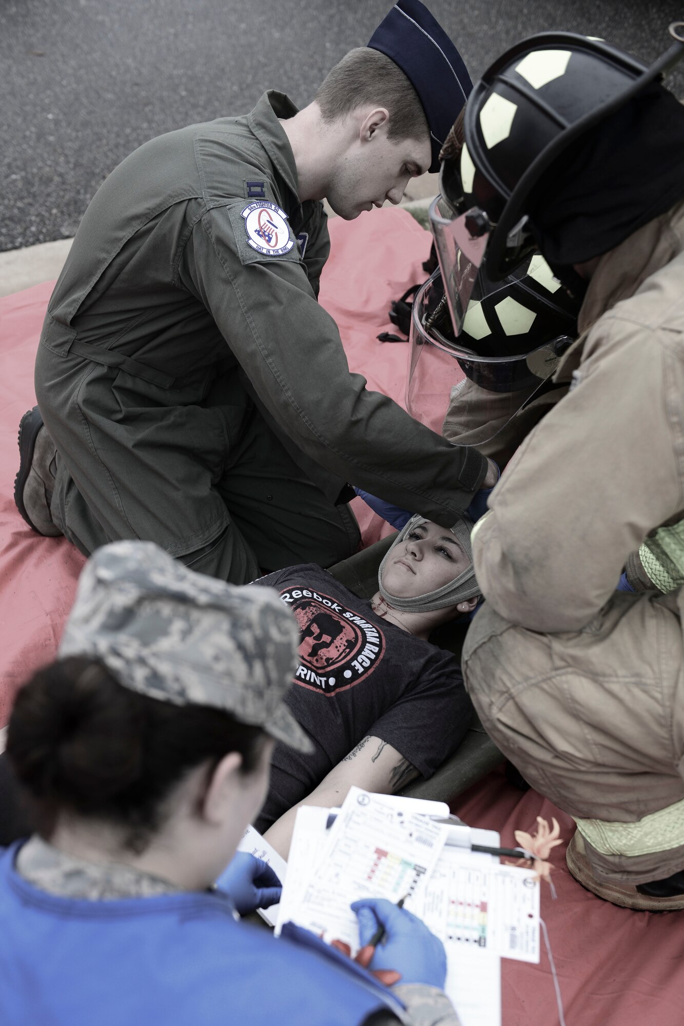 Emergency responders treat a role player victim during an active shooter exercise at Langley Air Force Base, Va., Nov. 19, 2015. During the exercise personnel were tested on mass casualty response and services, casualty tracking procedures, fatality management services and next of kin notification procedures. (U.S. Air Force photo illustration by Staff Sgt. Ciara Gosier)