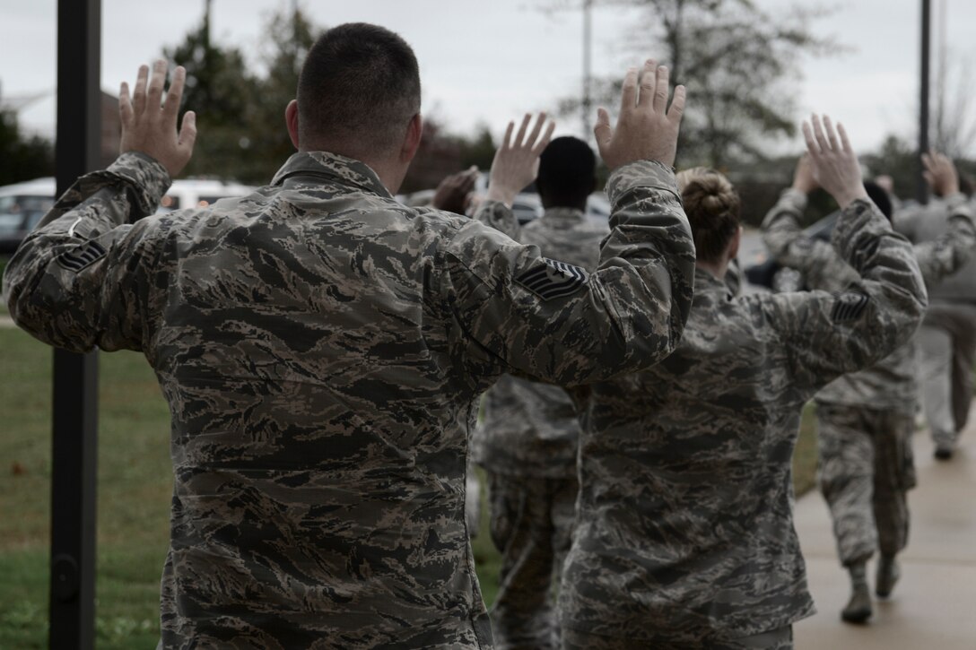 U.S. Airmen exit a building during an active shooter exercise at Langley Air Force Base, Va., Nov. 19, 2015. During the exercise, the shooter entered their building which alerted the building residents to execute lockdown procedures until security forces arrived to allow them to exit. (U.S. Air Force photo illustration by Staff Sgt. Ciara Gosier)